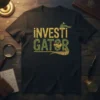¡INVESTIGATOR text with a sunglasses-wearing alligator graphic on a black t-shirt