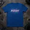 Blue t-shirt with "#okurr" in white glitch text over a pink and green circuit board graphic